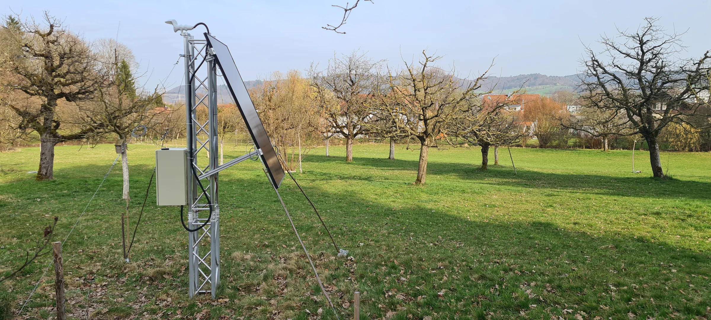 Installierter HUVI.GUARDIAN Prototyp mit Solarpanel und Abspannung in einer Obstwiese